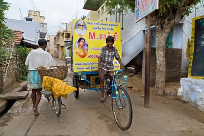Boy on Poster-Bike in Narrow Street Canvassing for Party Political Elections by Unbekannt Unbekannt